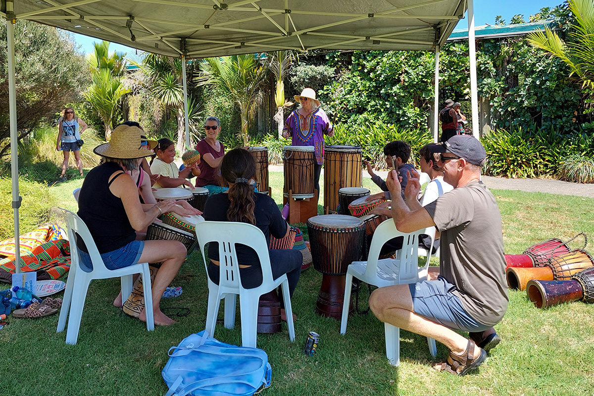 A group of people sitting in a circle drumming.